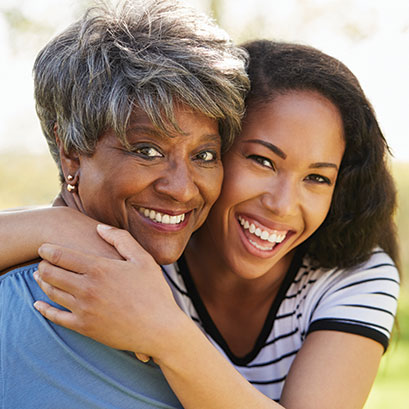 A woman and her daughter hugging and smiling together. Closely Held Business Stock